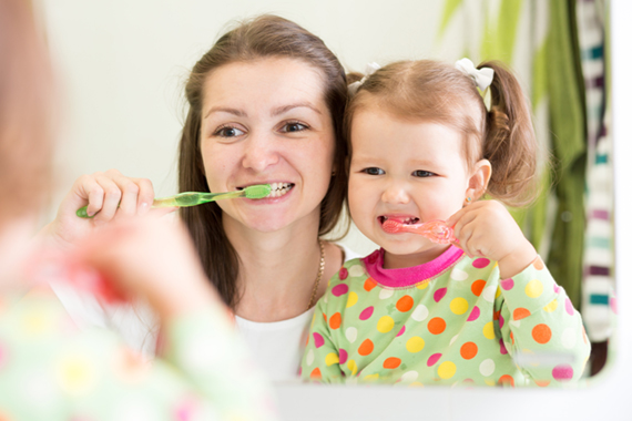 mum and girl brushing teeth